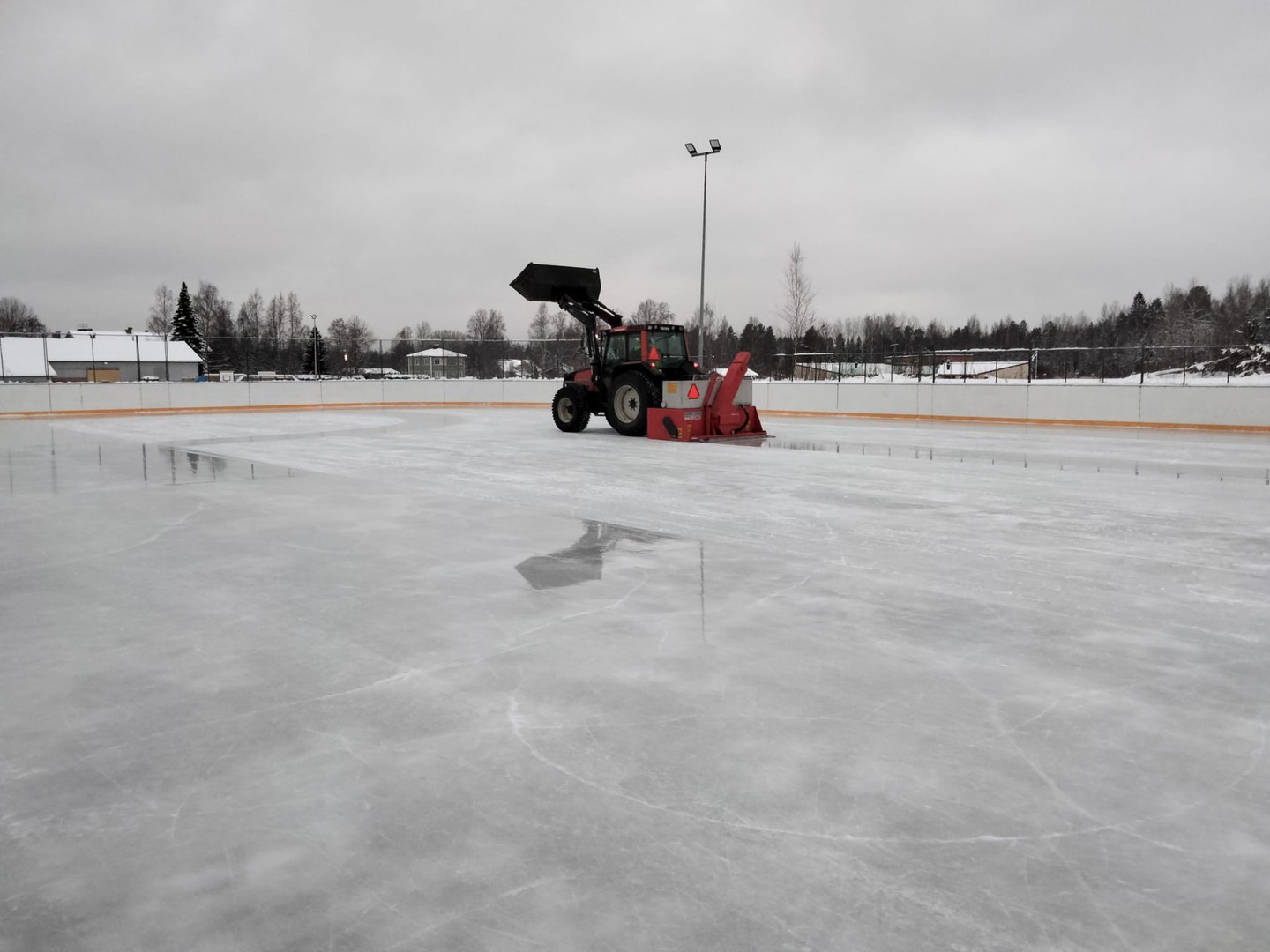 Kuva luistinradasta, jota huolletaan traktorilla